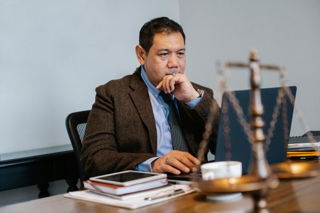 Asian male executive working intently on laptop, symbolizing focus and professionalism.